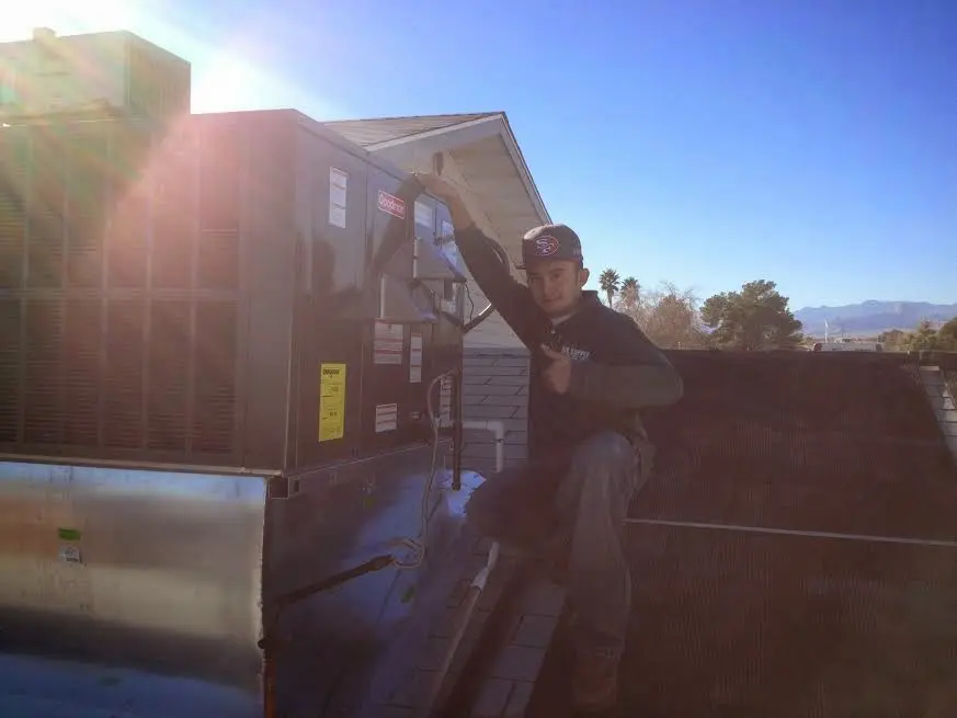 HVAC technician performing Air Duct Repair on a rooftop unit in Deschutes River Woods